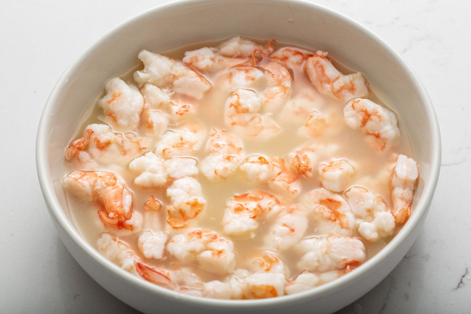 Shrimp in lime and lemon juice for a shrimp ceviche recipe.