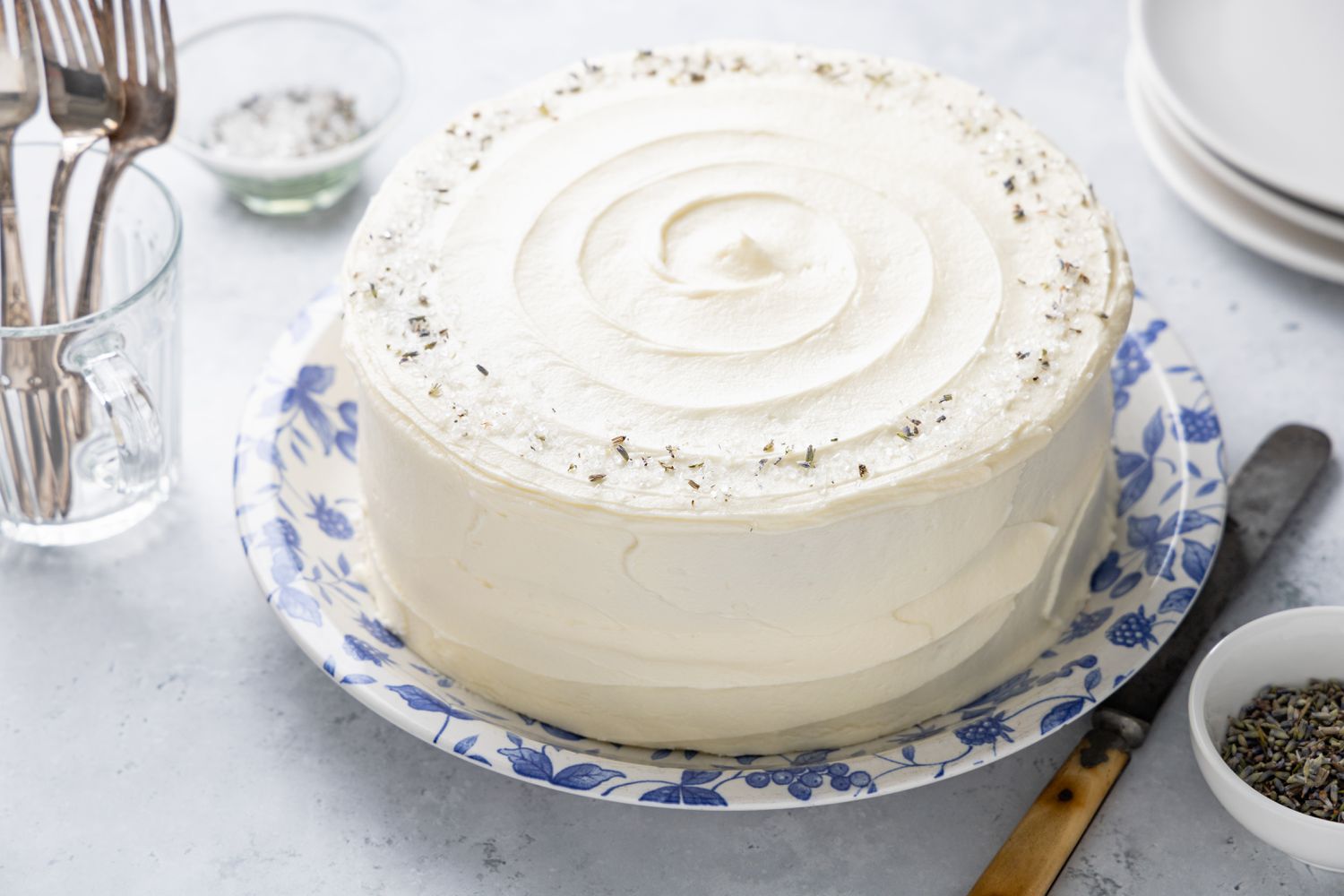 Lemon Lavender Cake Surrounded by Forks, a Small Bowl of Lavender, and Plates