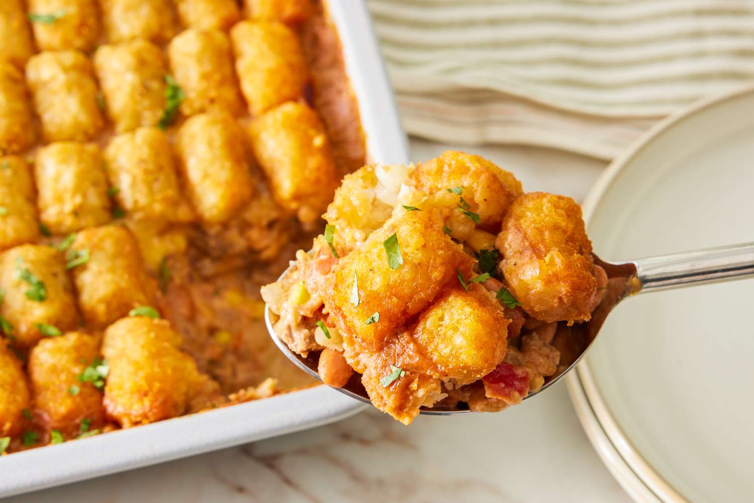 spoonful of cowboy casserole lifted from a casserole dish with more