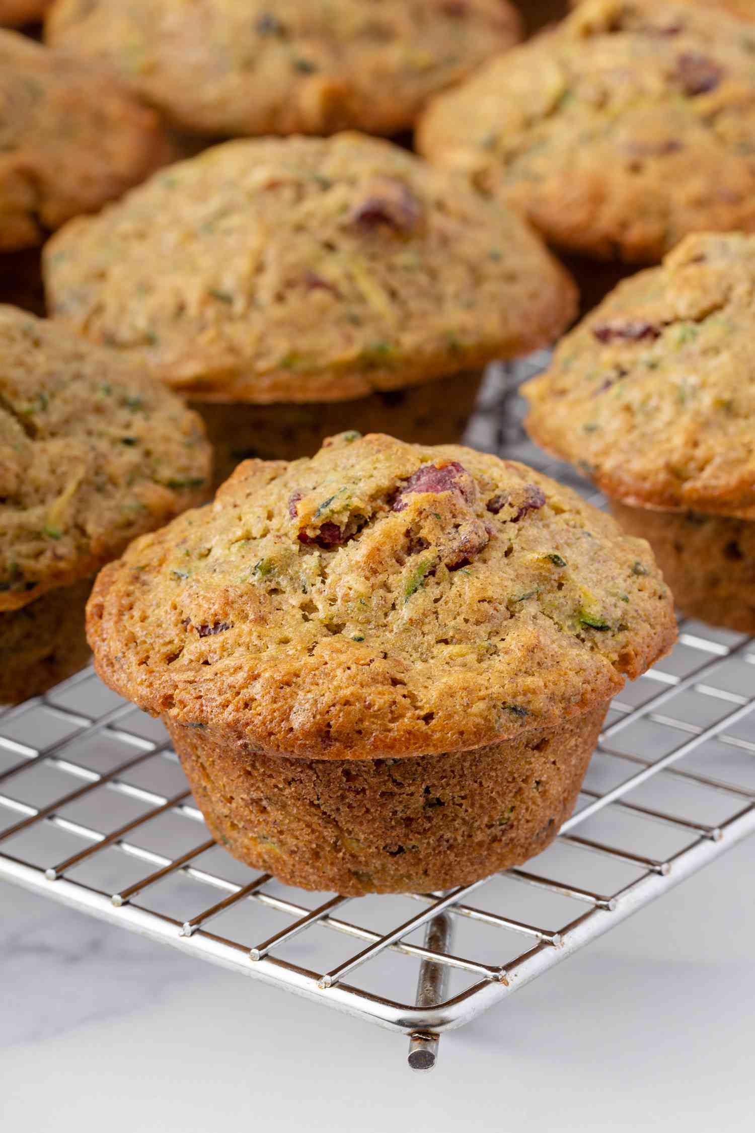 Zucchini muffins cooling on a rack.