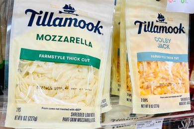 Packages of Tillamook shredded mozzarella and Colby Jack cheese on a store shelf
