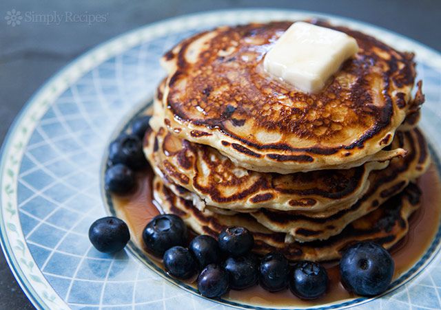 Blueberry Pancakes stacked high with butter and fresh blueberries