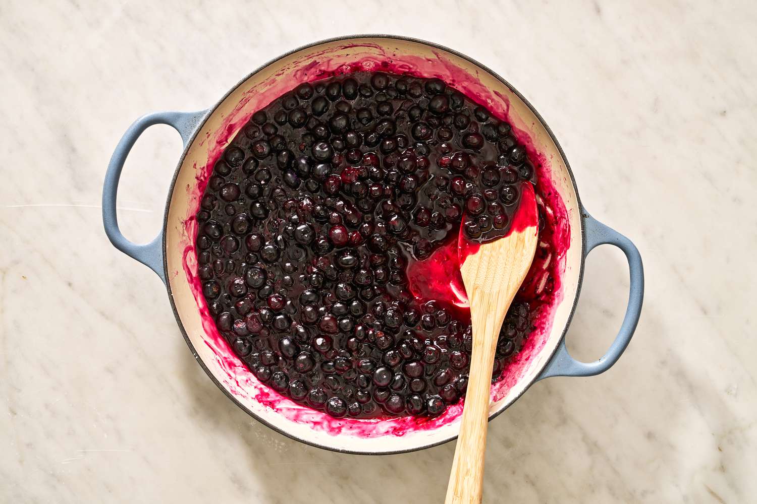 cooked blueberry filling in a braiser for blueberry grunt recipe