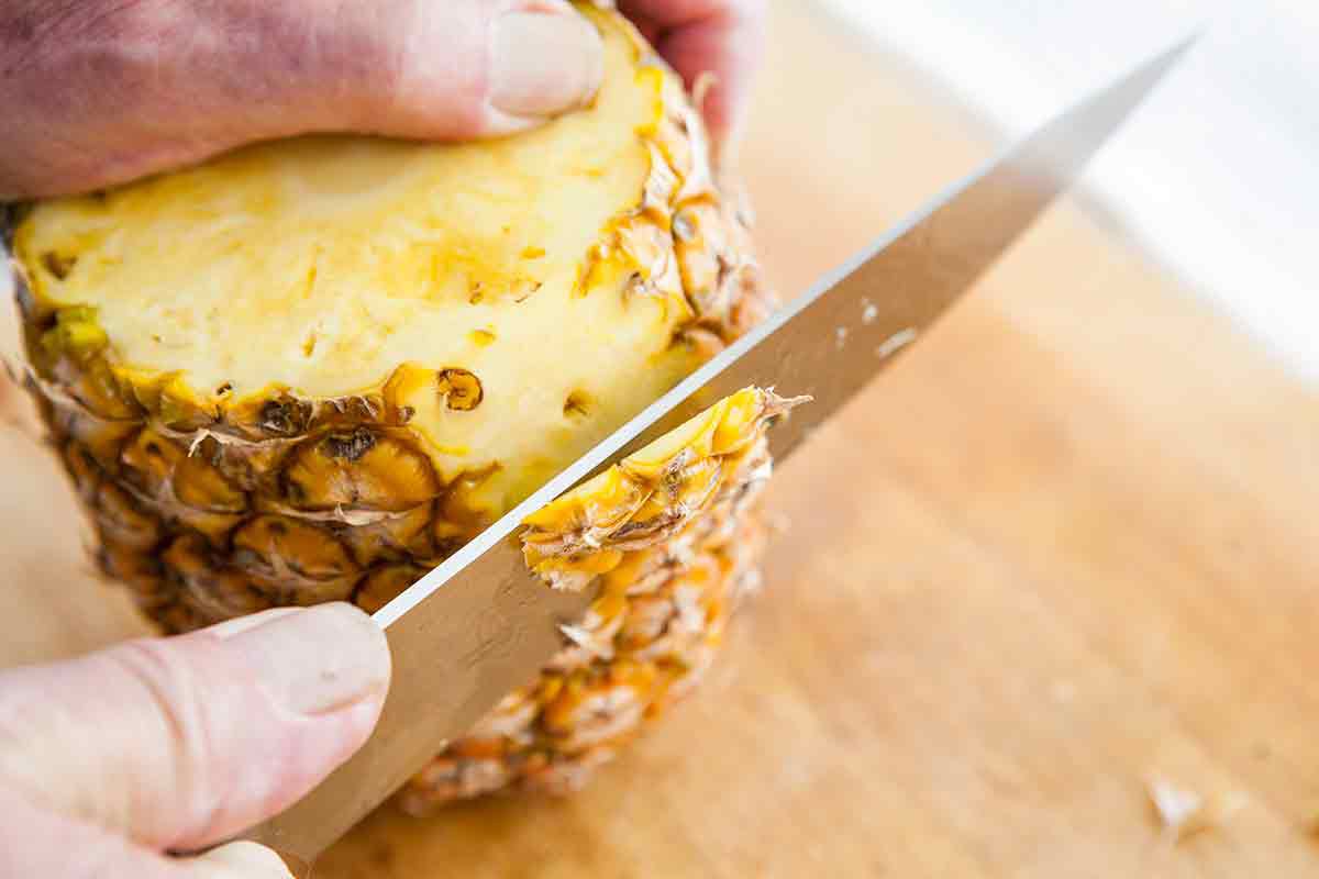 cut off the outer skin of the pineapple close to the edge
