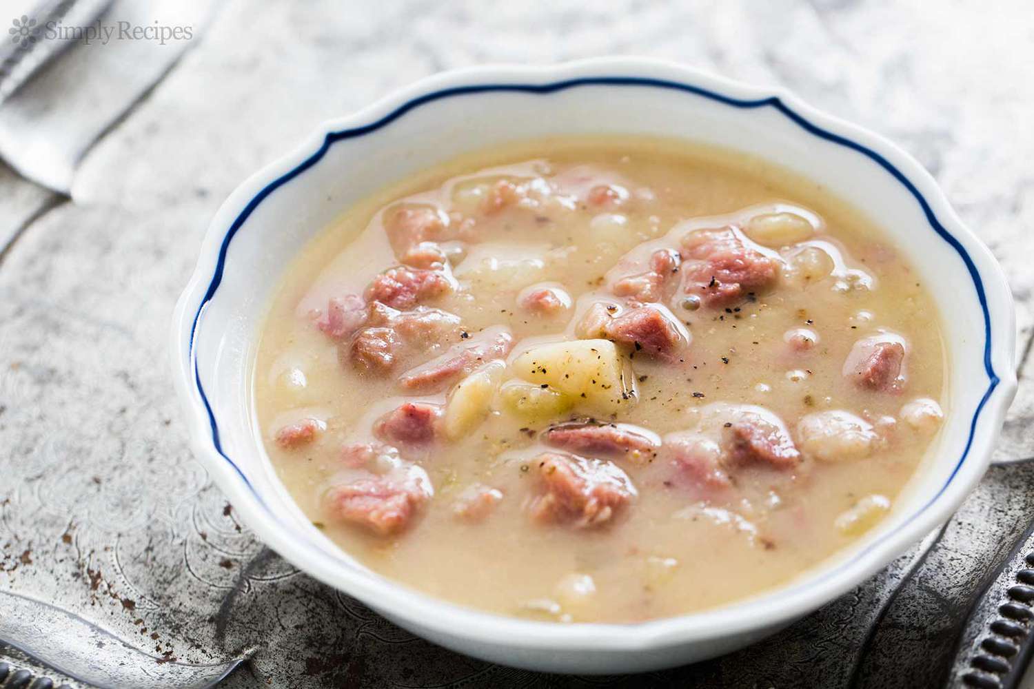Ham and Potato Soup in a white bowl with blue trim on a silver platter
