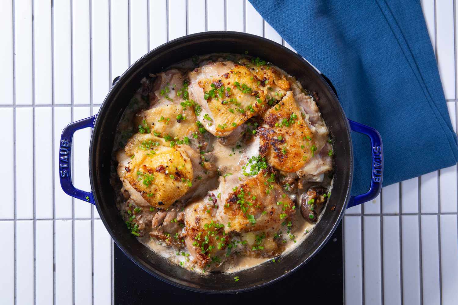 chicken fricassee in dutch oven topped with minced herbs