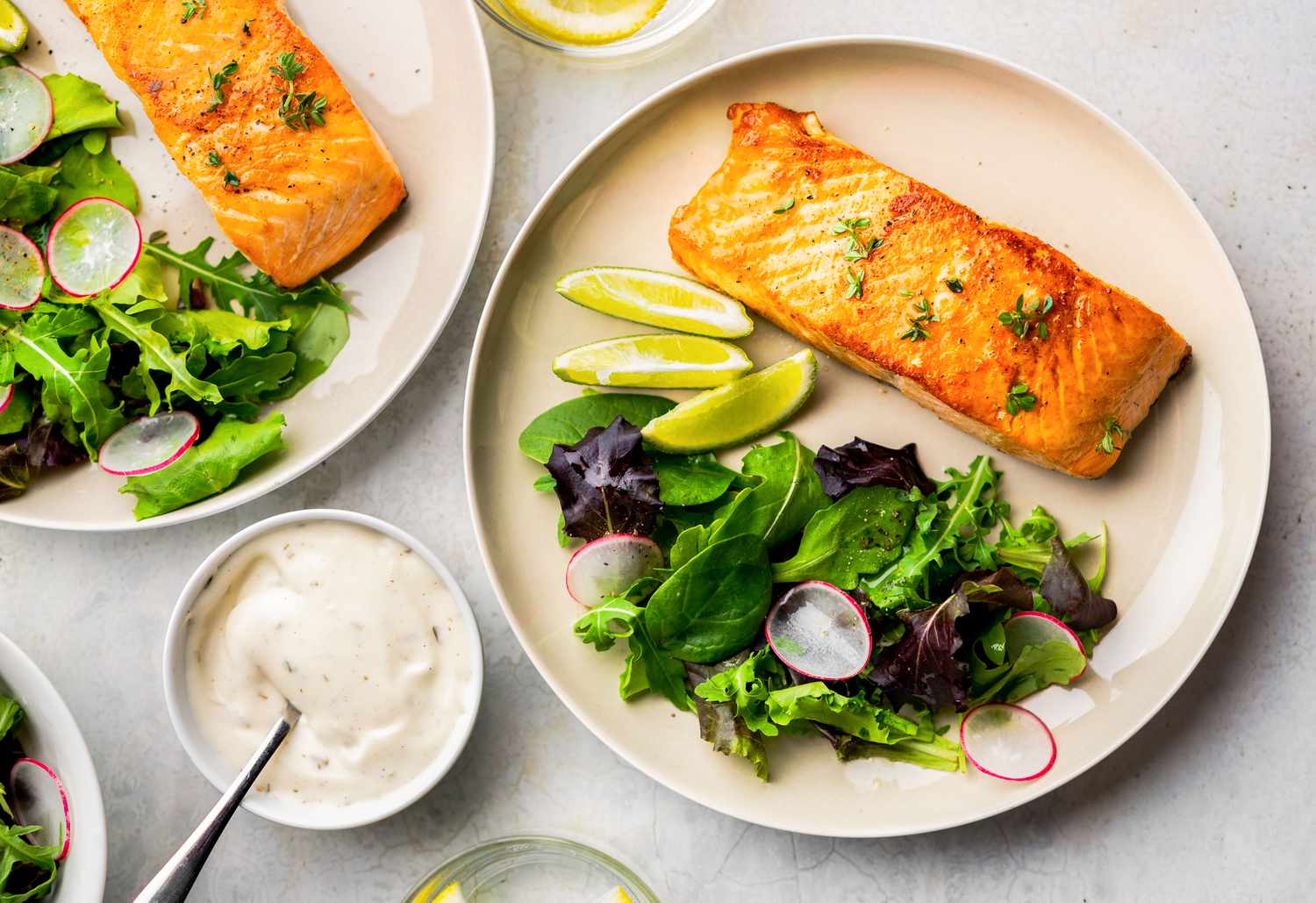 Salmon fillet on a plate with a side salad and lime slices