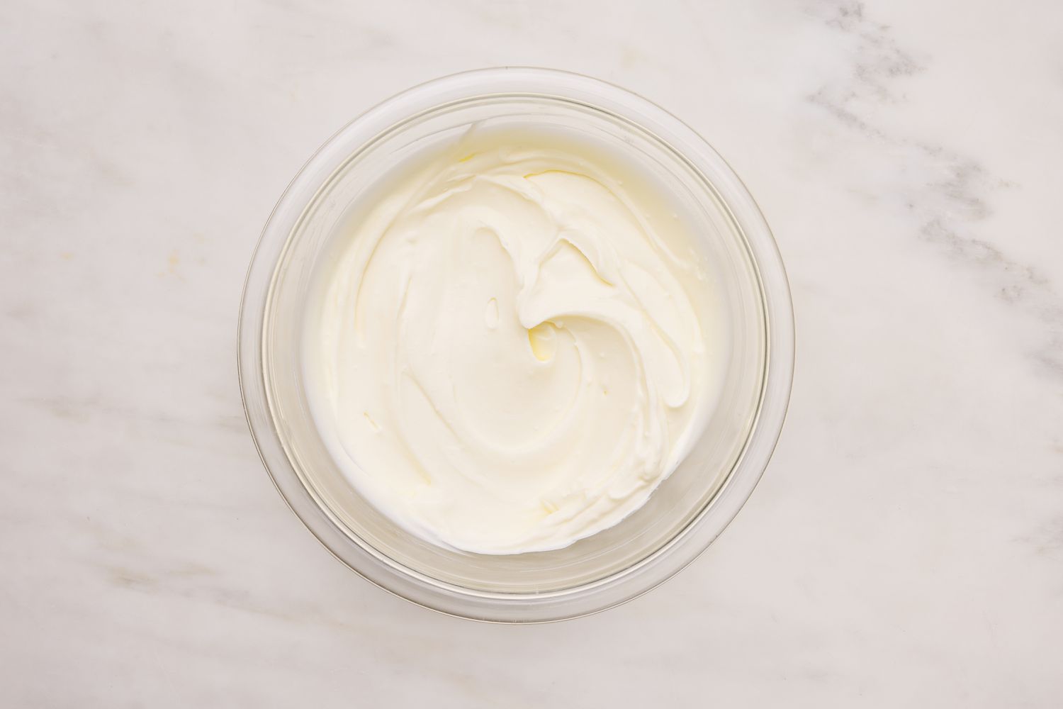 Bowl of blended cream cheese and cream mixture for spinach artichoke dip soup recipe