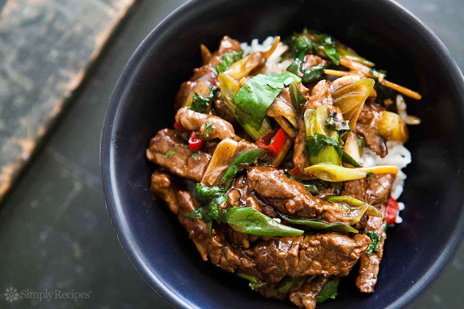 A bowl of stirfried beef with vegetables served over rice