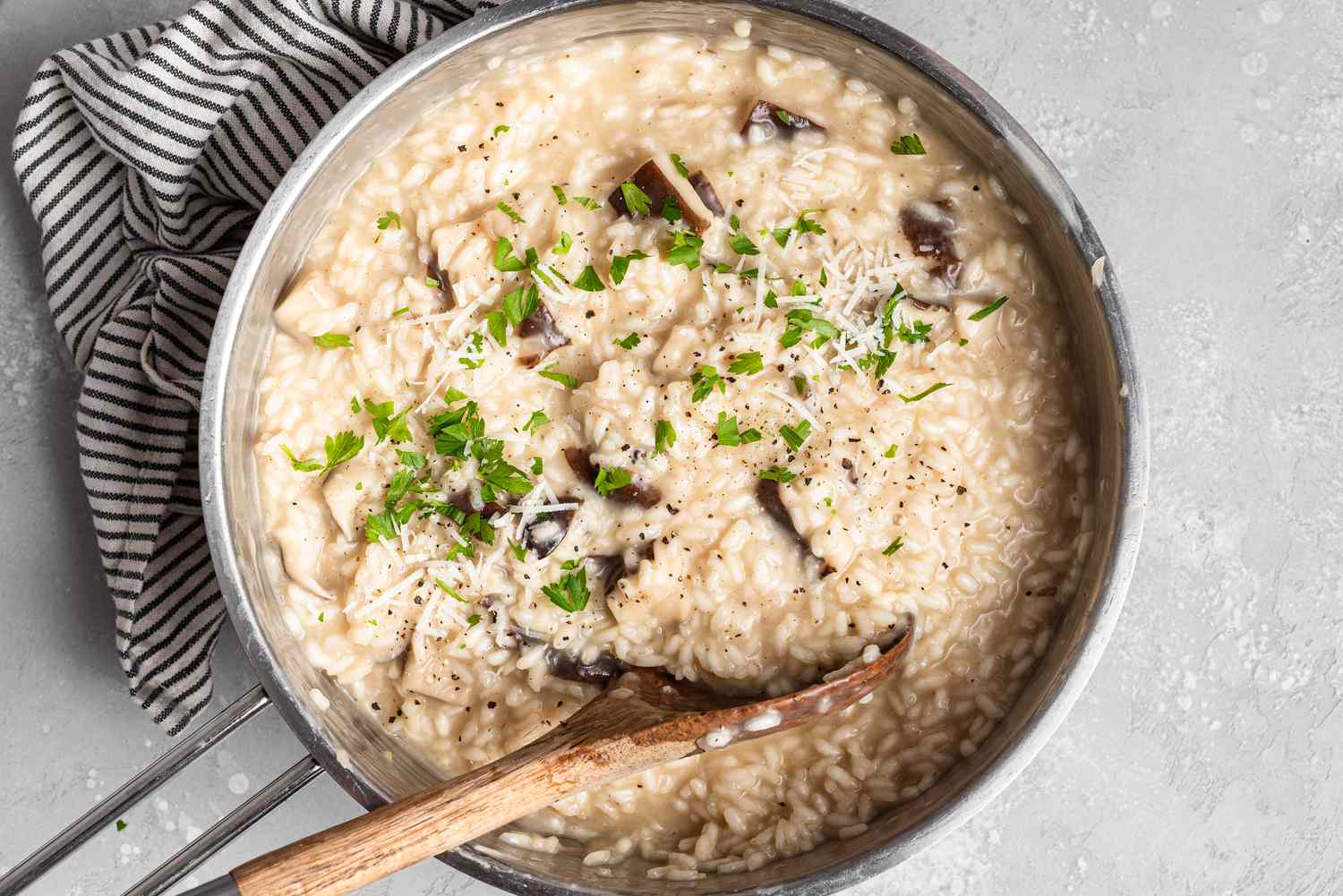 Parsley sprinkled over a cooked risotto in a pot