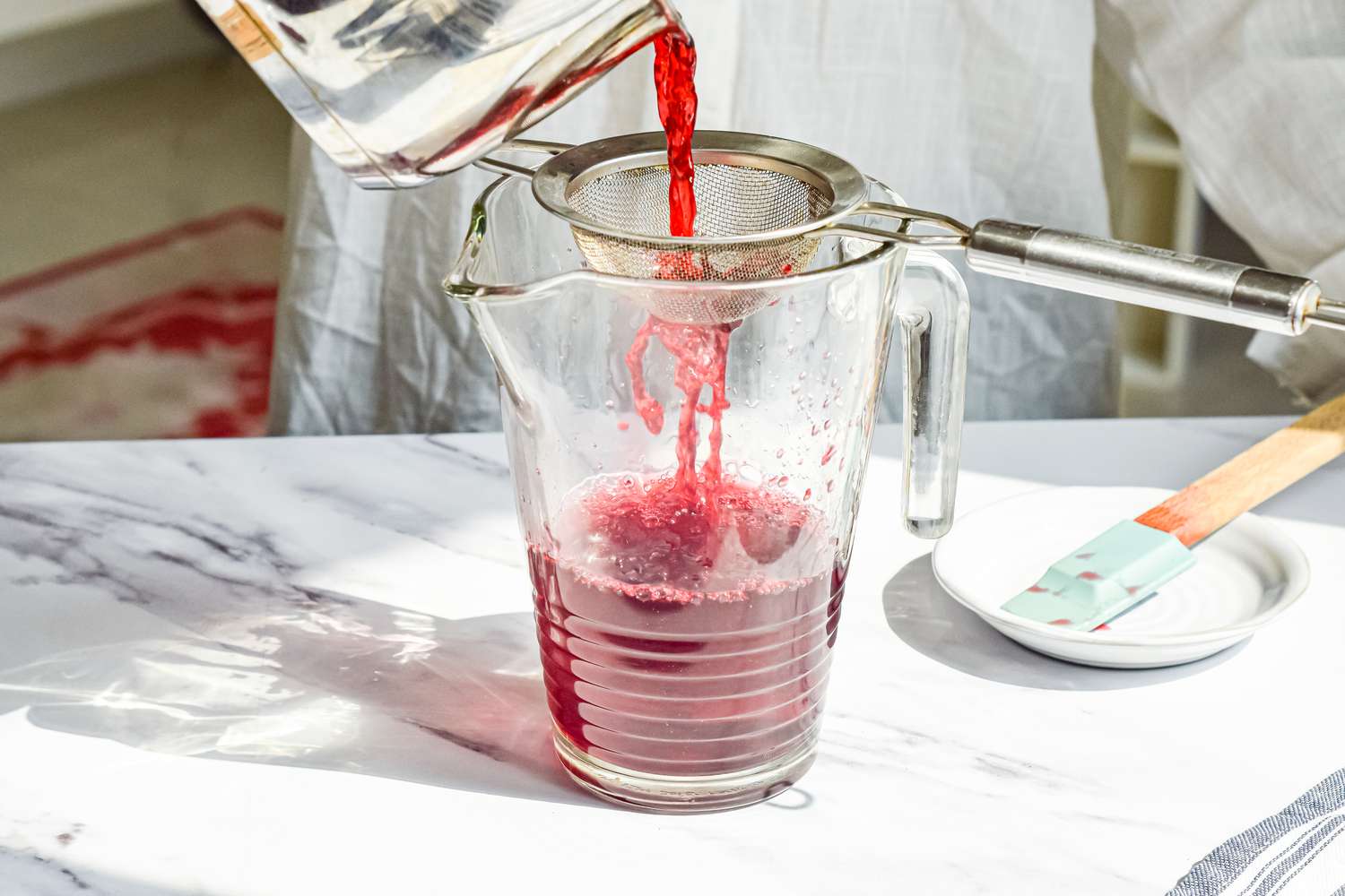 Agua de Jamaica (Hibiscus Tea) Strained into a Pitcher to Remove Flowers and Spices