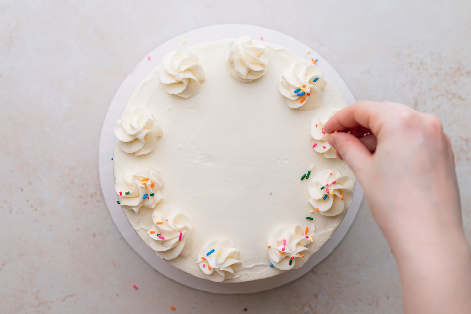 Decorating a Rainbow Layer Cake with Rainbow Sprinkles