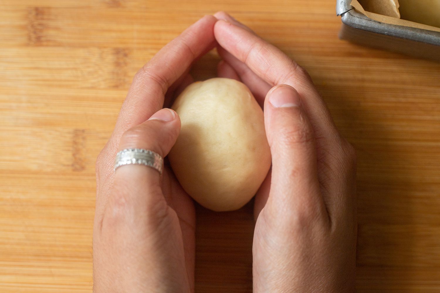 Rolling dough in hands for pull apart rolls with garlic and parmesan.