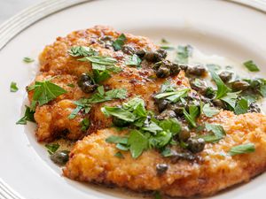 A helping of chicken piccata on a plate topped with sauce