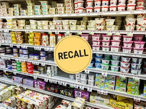 A supermarket aisle displaying yogurt products with a circular yellow recall notice graphic overlayed