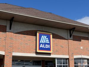The exterior of an Aldi grocery store with its logo displayed on a brick and stucco facade