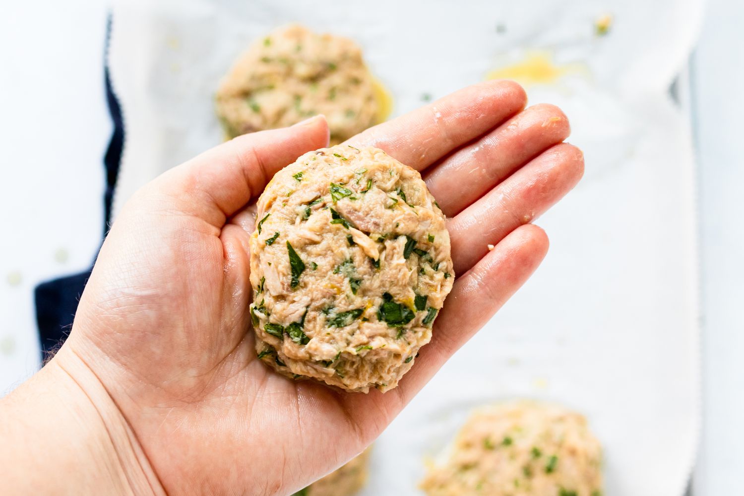 Pressing tuna patties together to show how to make tuna fish.