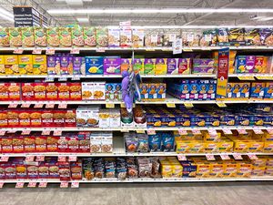 Shelves stocked with various brands of boxed macaroni and cheese in a grocery store aisle