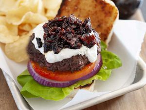 The best bacon jam on top of a hamburger with chips on the side.