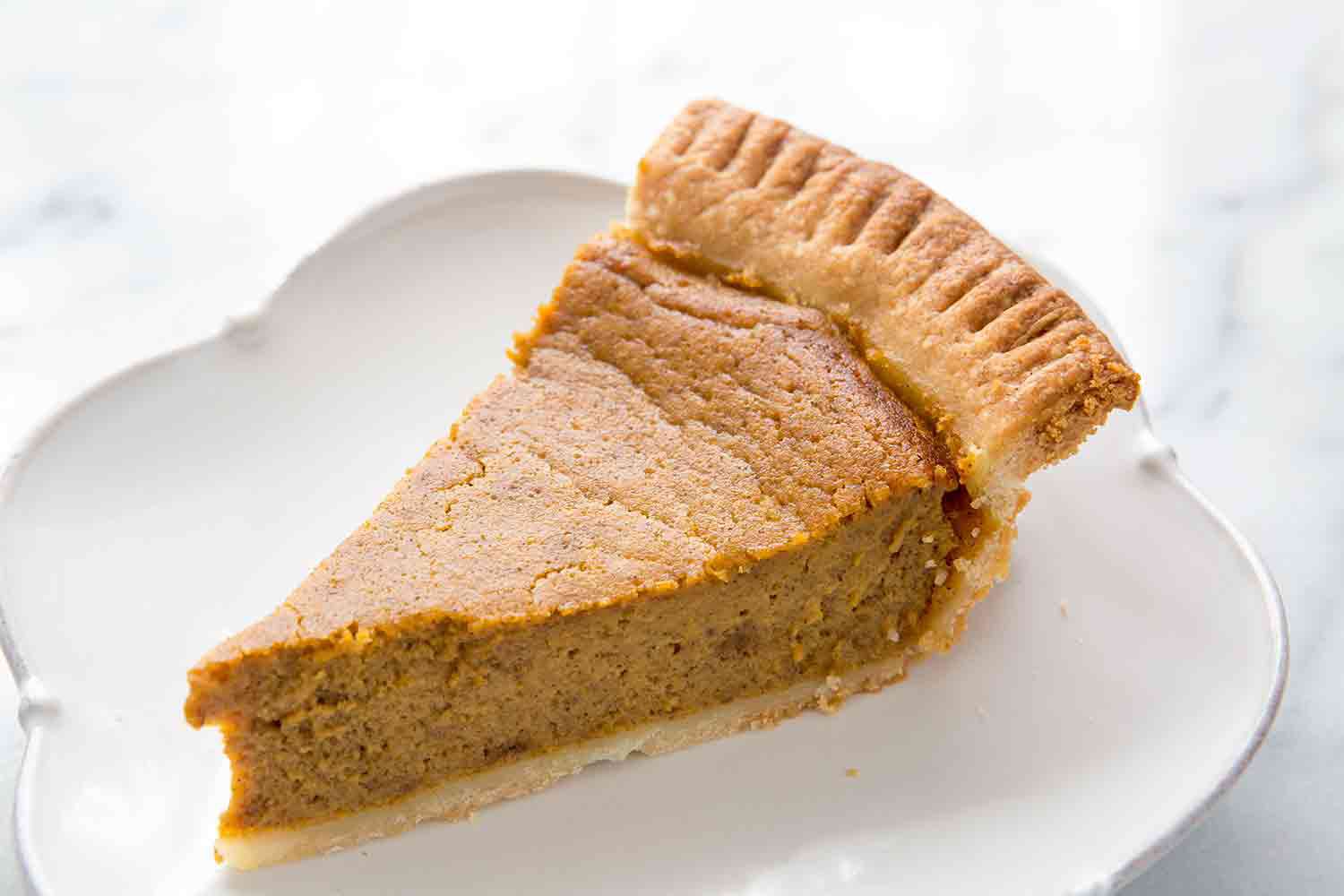 Pumpkin pie slice on hite plate