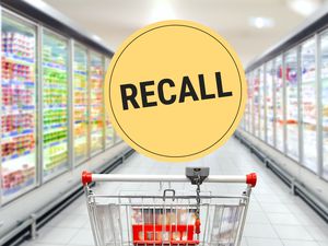 Supermarket aisle with a recall label overlay showing a shopping cart and refrigerated display cases