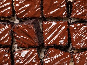 Slices of chocolate cake topped with shiny chocolate frosting