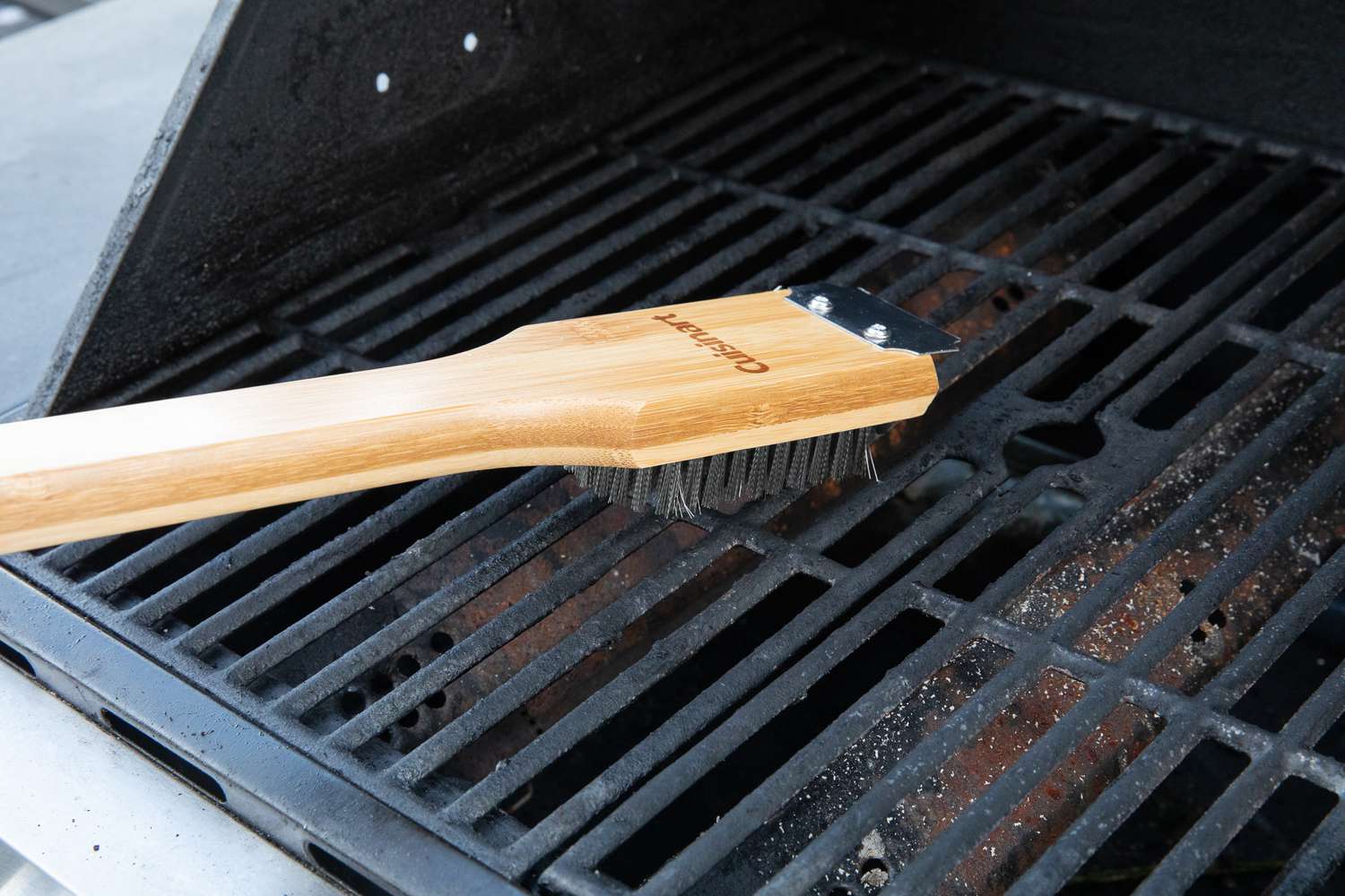 a grill being cleaned with a grill brush