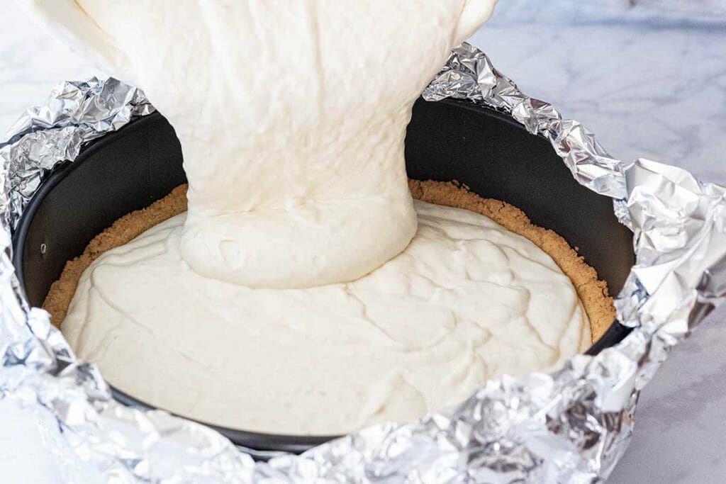 Banoffee Pie Cheesecake - Pouring batter into pan, aluminum foil on side
