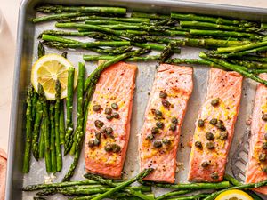 Overhead shot of baked salmon fillets and asparagus on a baking sheet