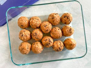 Overhead view of 5-ingredient energy balls in a clear glass bowl on marble counter