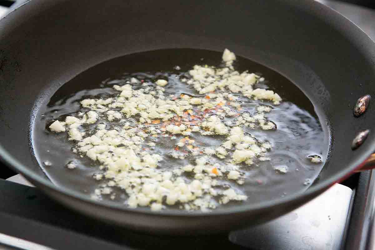 saute garlic and chili flakes to make clam sauce for spaghetti