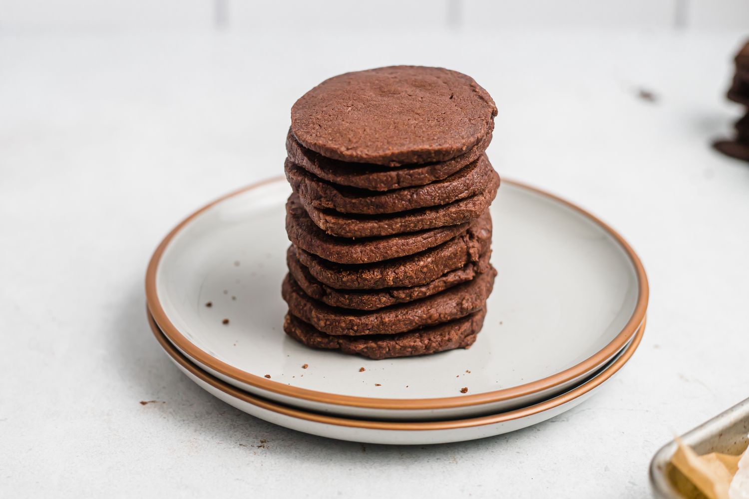 Tender chocolate butter cookies stacked on a ceramic plate.