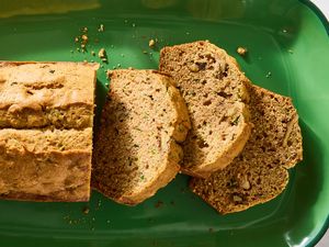 Sliced zucchini bread on a green serving tray