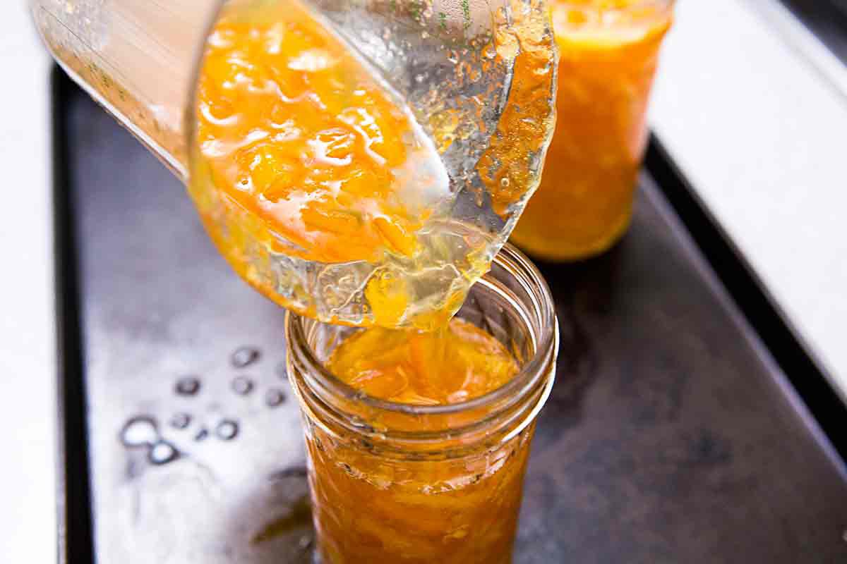 pour orange marmalade into jars