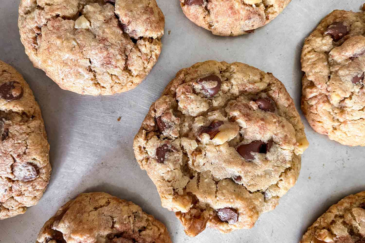 Chocolate chip cookies sitting on parchment paper. 