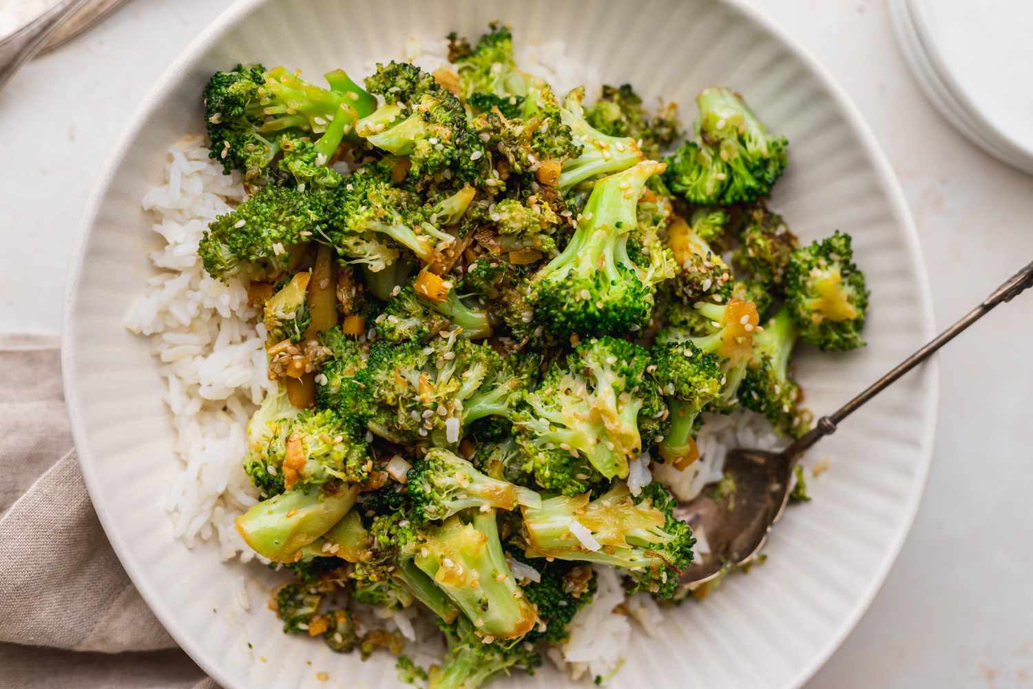 Overhead view of a plate of broccoli stir fry recipe served over rice.