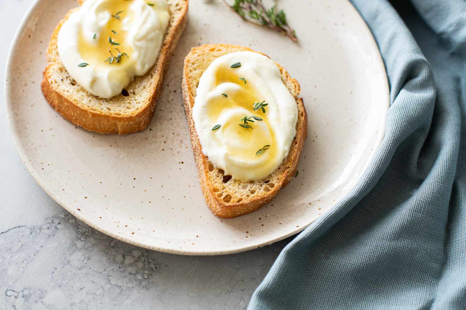 Two Pieces of Whipped Ricotta Toast Topped with Honey