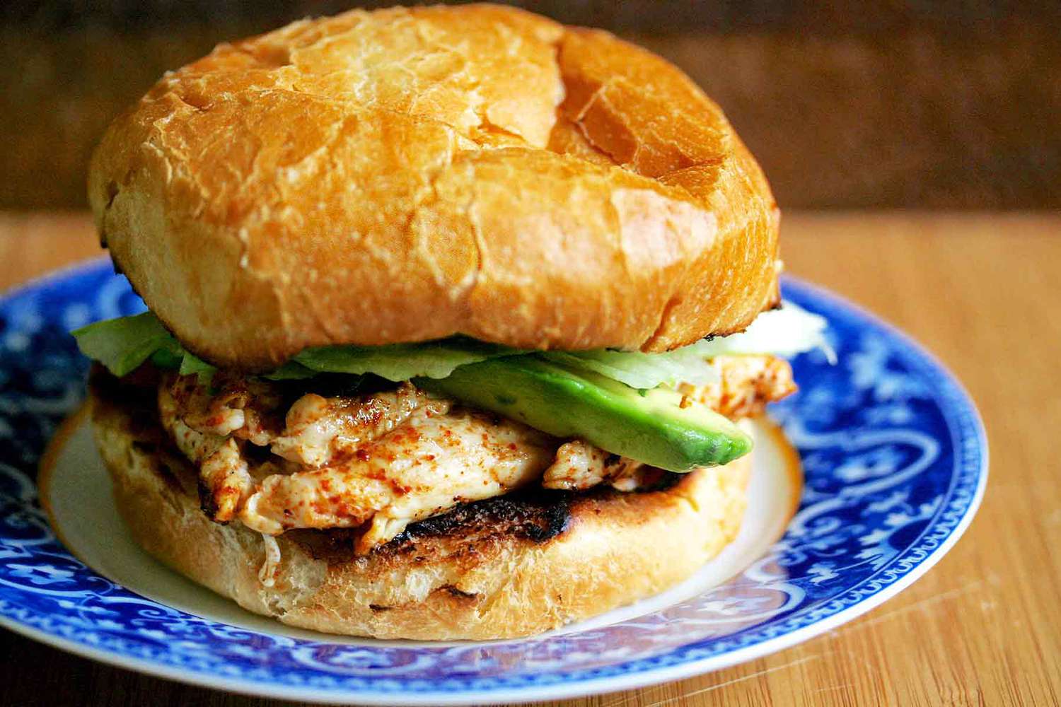 A chipotle chicken and avocado sandwich on a plate, ready to serve