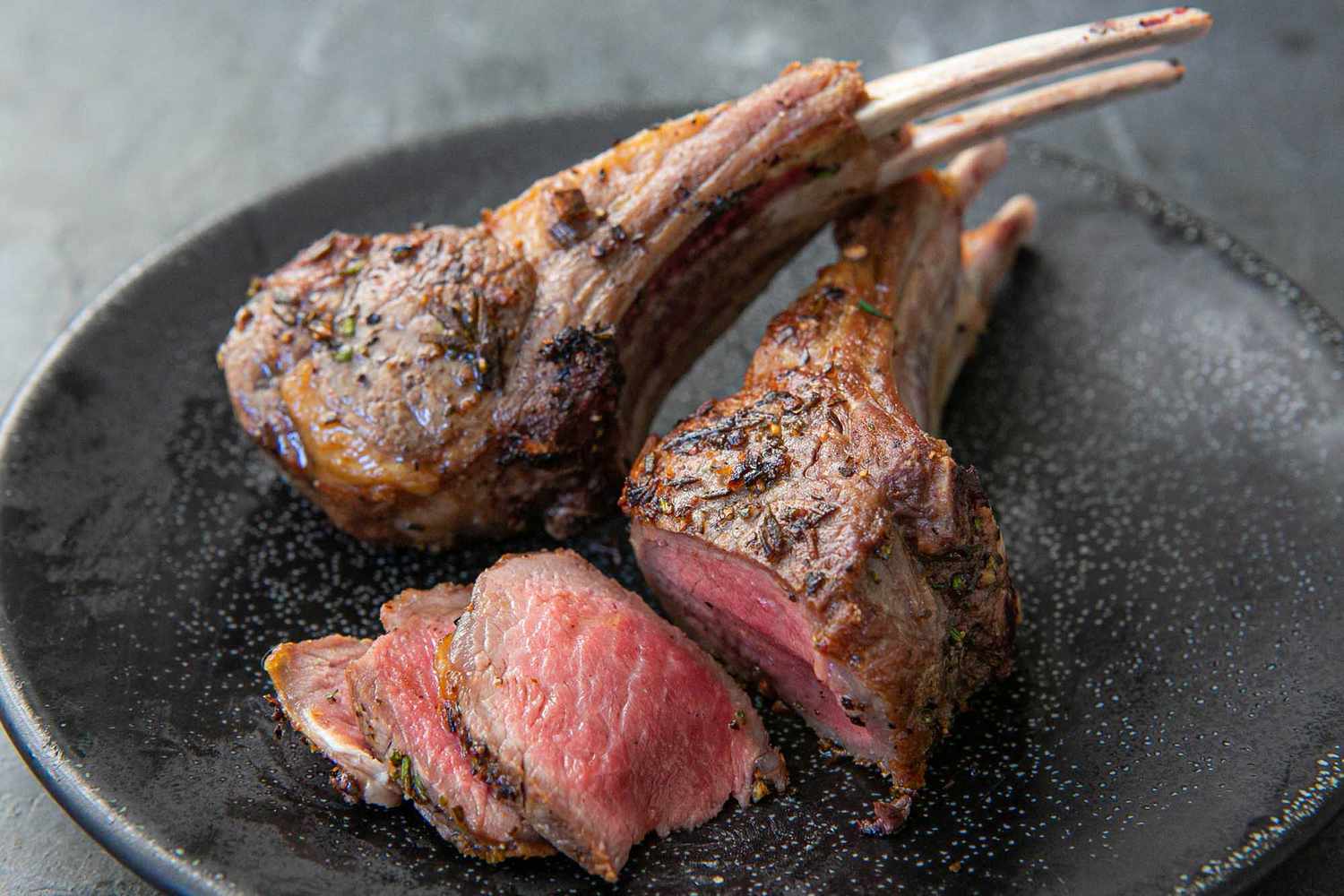 Lamb Lollipops cooked rare, sliced, and served on a plate