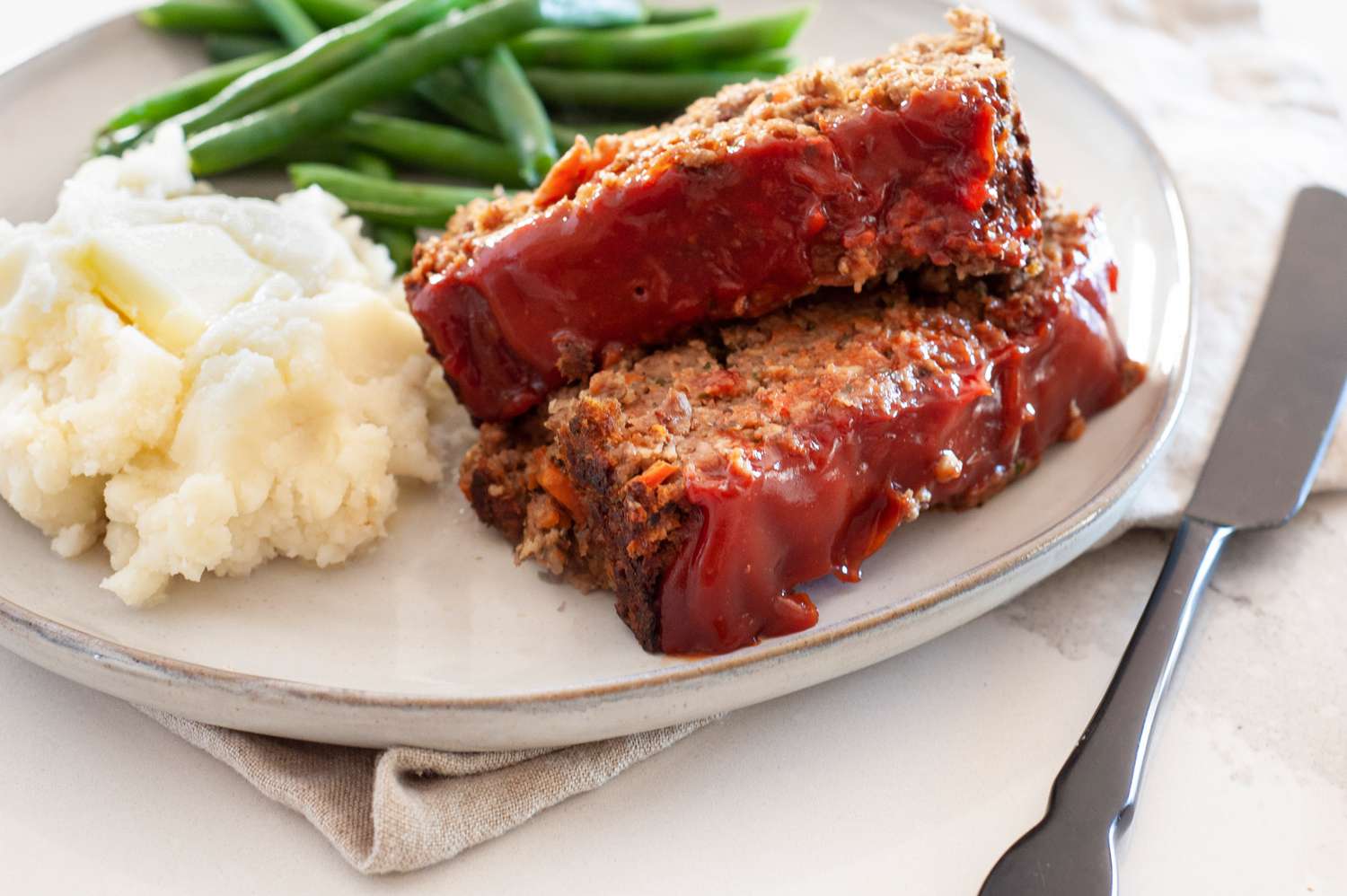 Vegetarian Meatloaf on a Plate with Mashed Potatoes and Green Beans