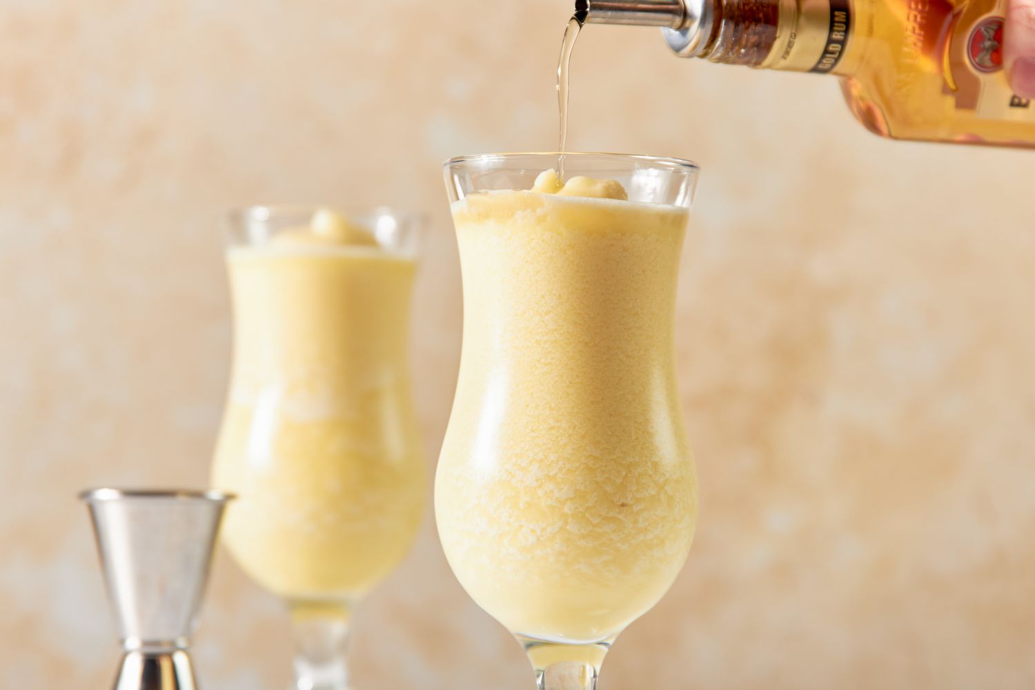 Glasses of PiÃ±a Colada Topped With Golden Rum 