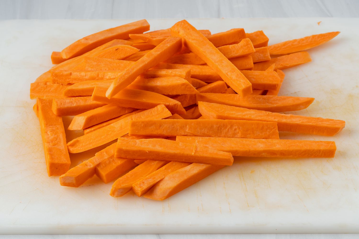 Sweet potatoes sliced into wedges to make fries