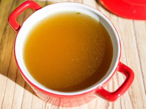chicken broth in a red bowl