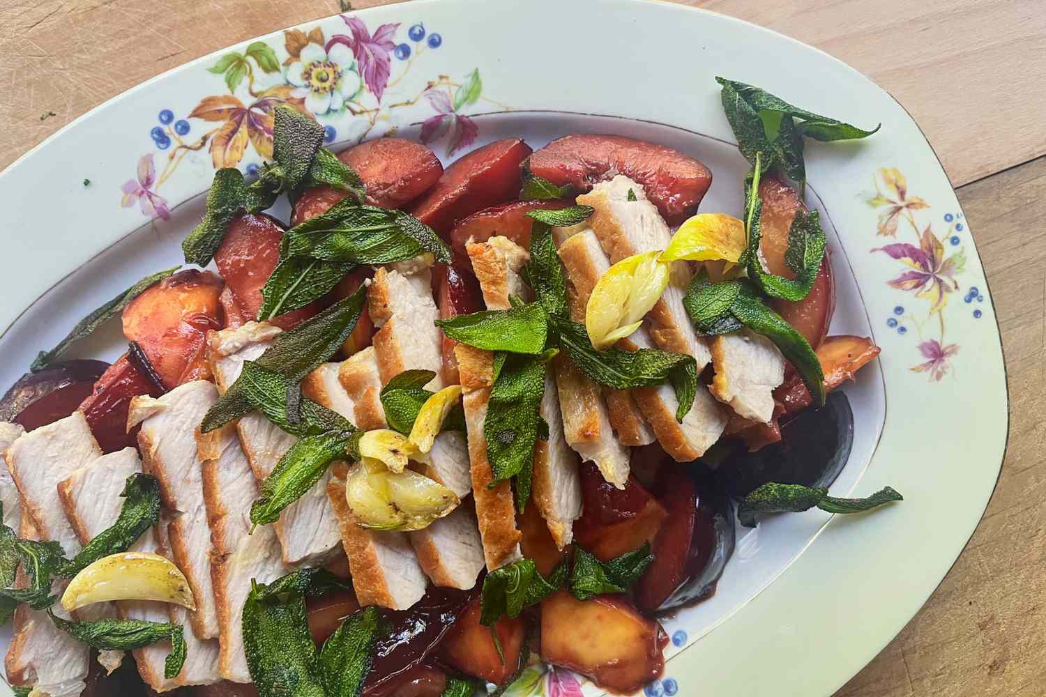 A plate of sliced pork chops garnished with herbs and vegetables