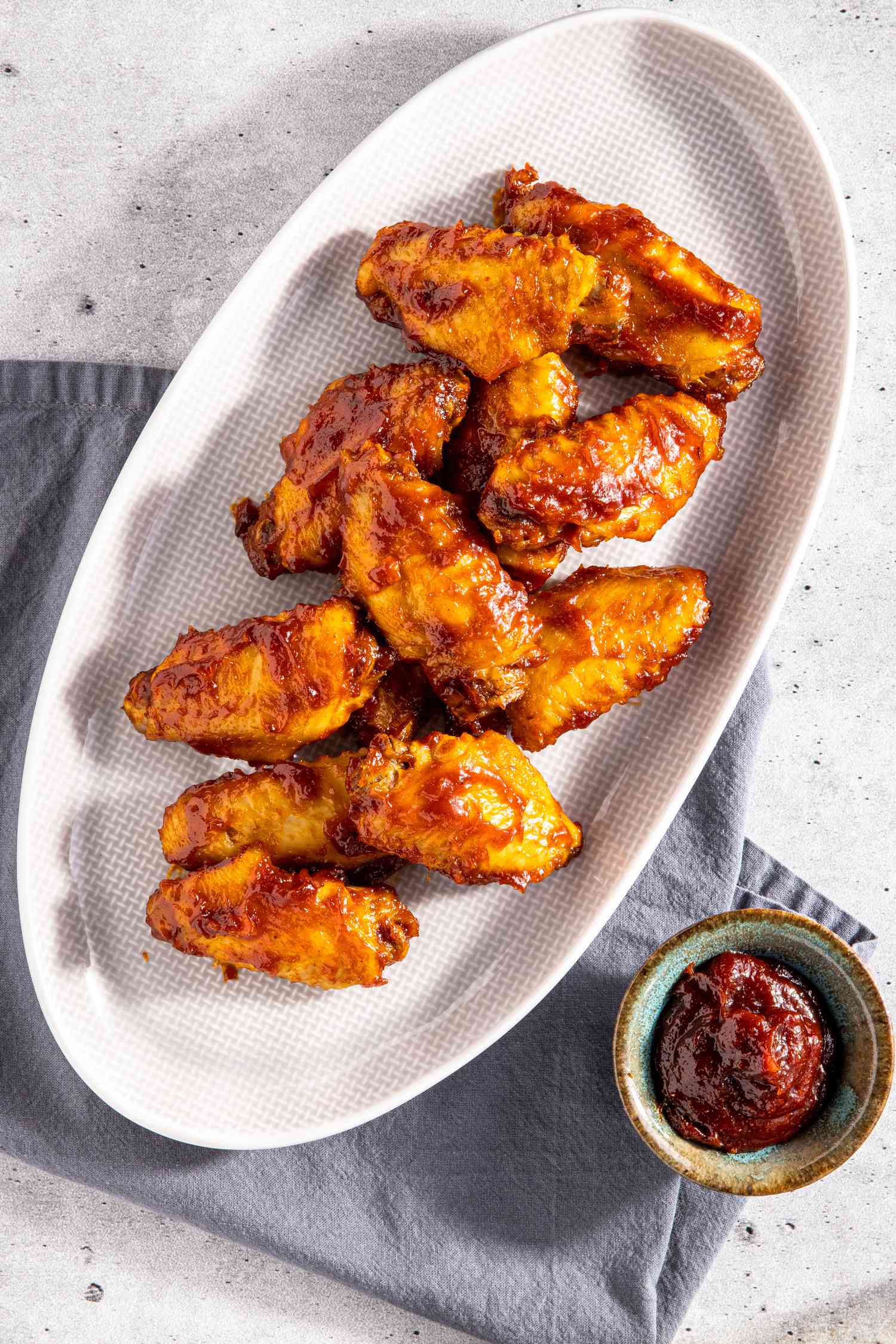 Platter of Microwave BBQ Chicken Wings with a Bowl of BBQ Sauce Next to It