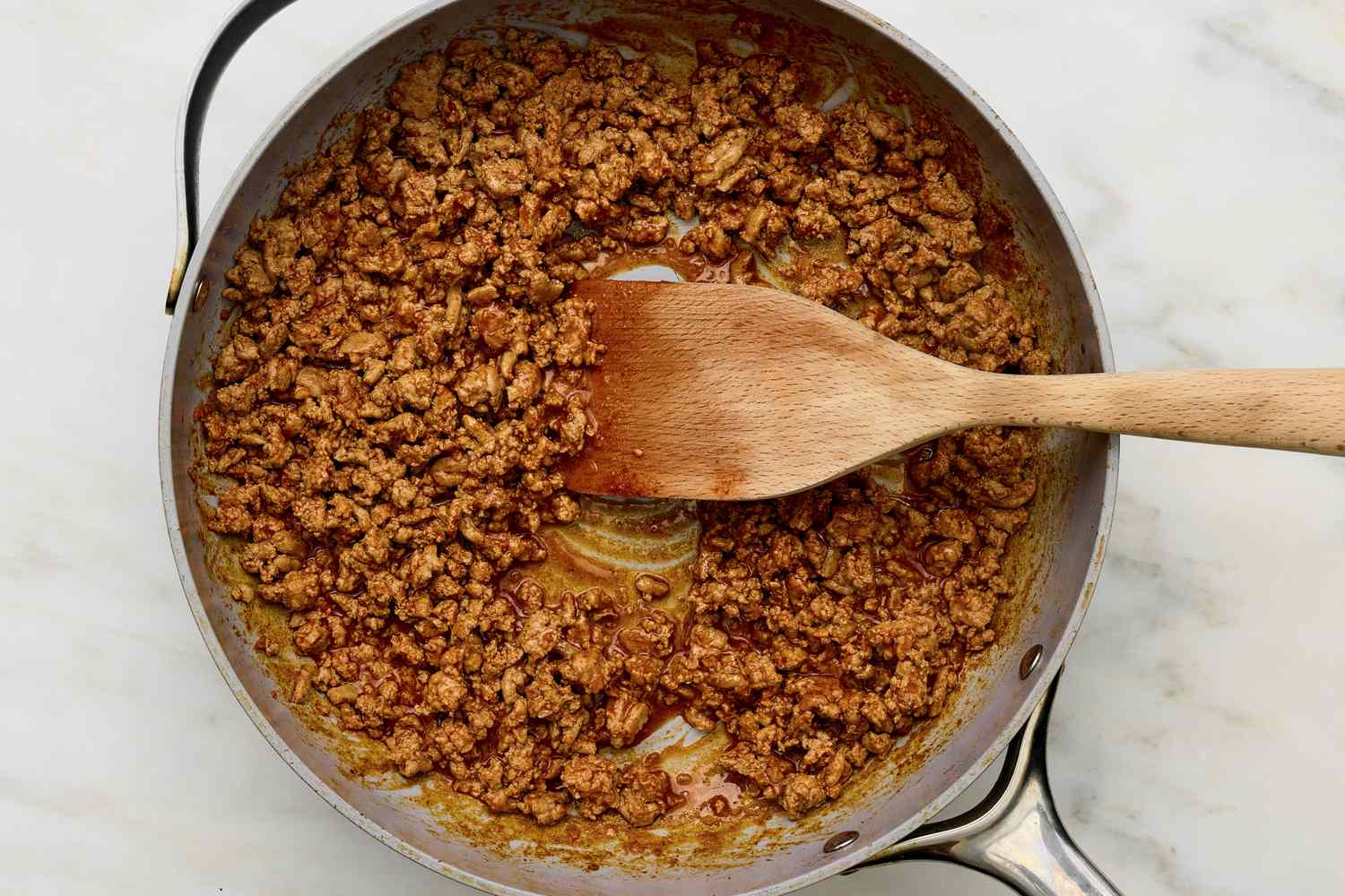 Taco seasoning mixed into the ground turkey in the skillet for 5-ingredient turkey taco bowl recipe