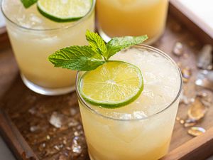 What's in a Mai Tai? closeup peach orange cocktail with lime and mint garnish