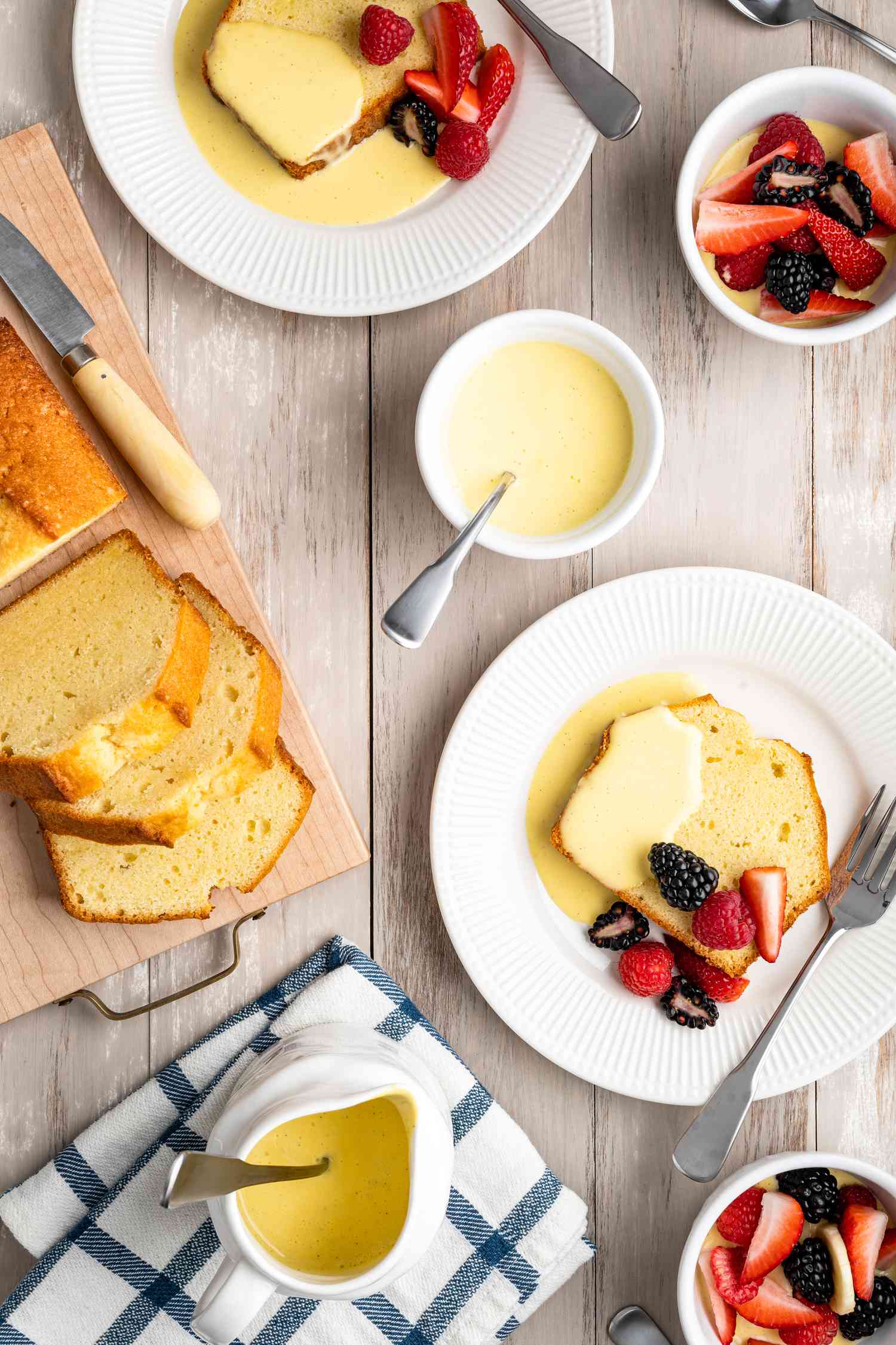 Table Setting with Bowl of Crème Anglaise, Plates of Pound Cake Covered with Creme Anglaise and Fruits, and Platter of More Pound Cake