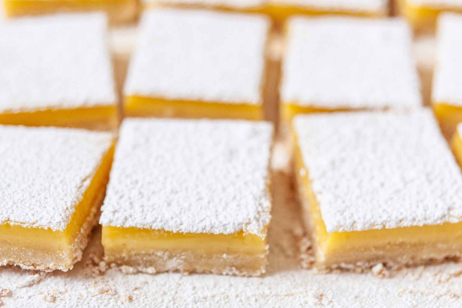 Lemon Bar Recipe - lemon bars with powdered sugar on cutting board