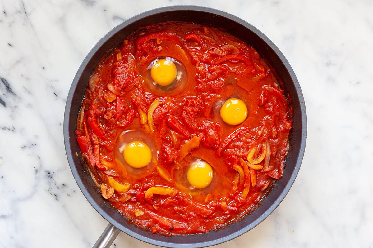 Eggs added to a skillet to make the Best Shakshuka.